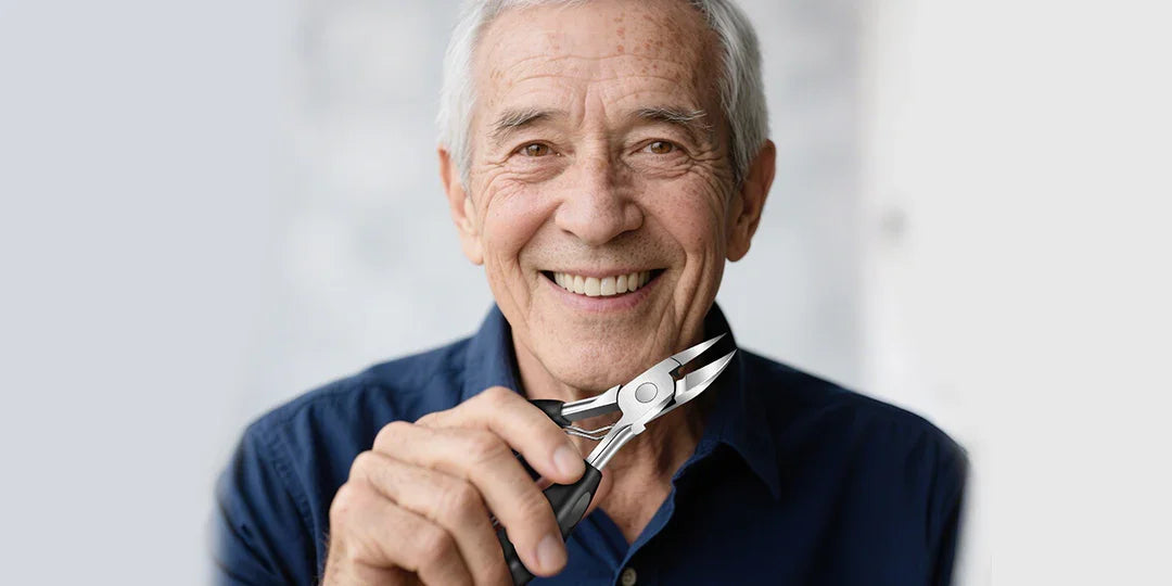 Smiling elderly man holding precision nail clippers against a light background